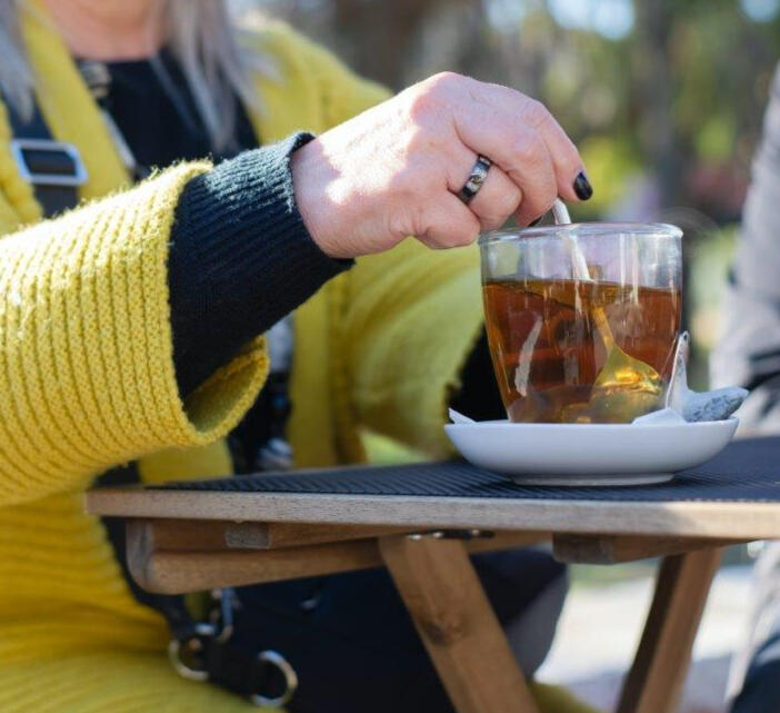 image of woman with citron sweater and dark nail polish stirring cup of tea for Peppermint Tea and Pie